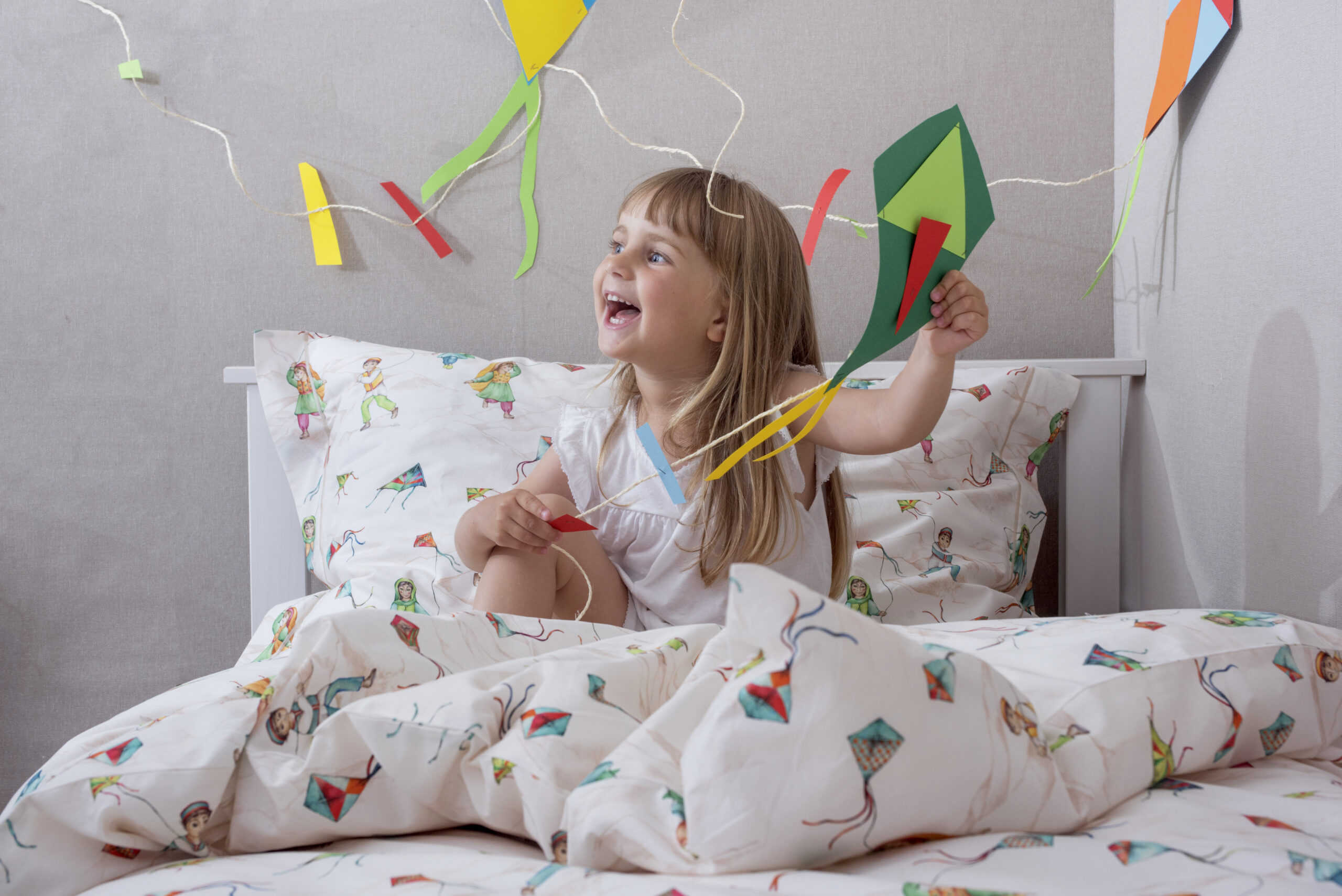 girl with a kite in the bedding with colourful textile pattern design